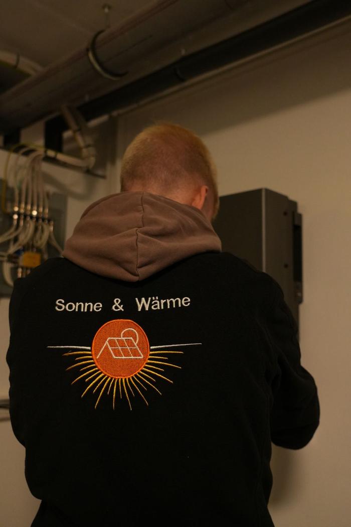 Elektriker von Sonne & Wärme von hinten am Wechselrichter