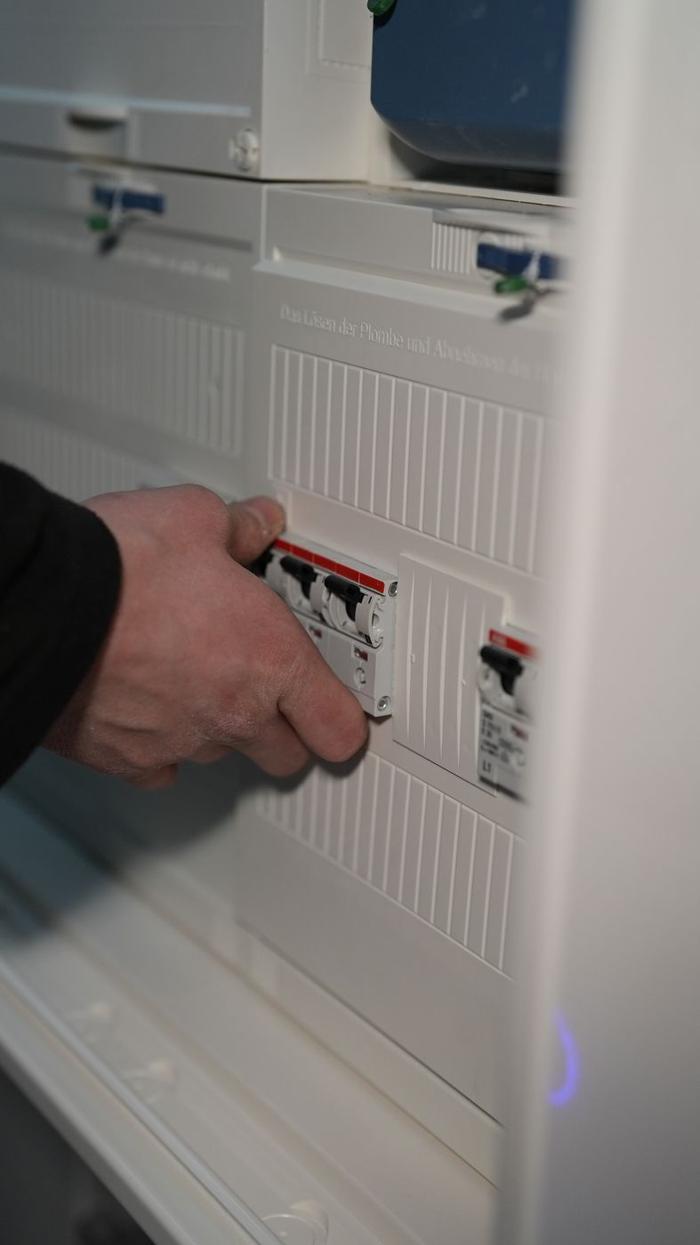 Elektriker schaltet die Sicherungen im Zählerschrank ab