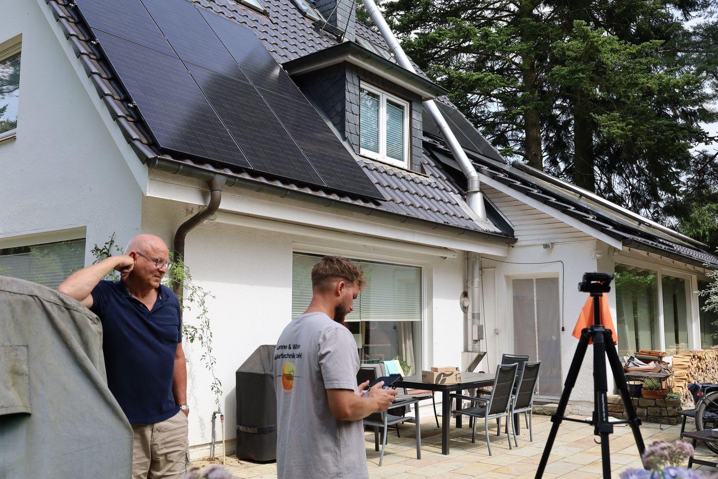 Projektleiter im Gespräch mit einem Kunden vor dessen Haus