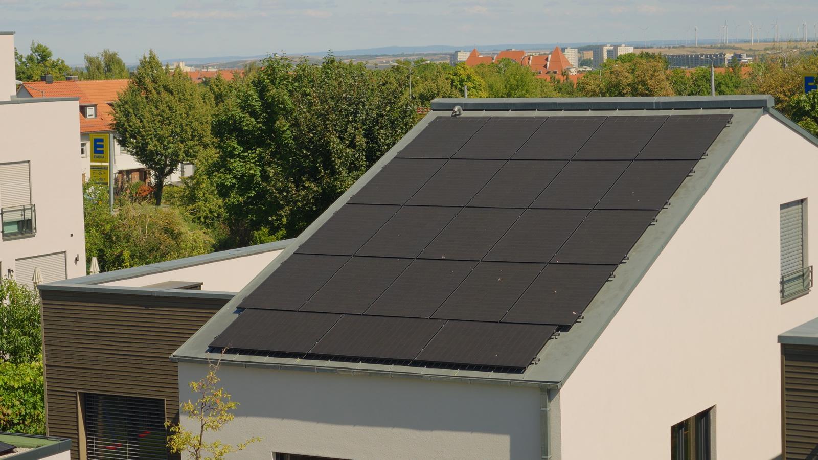 Vollflächig mit schwarzen Modulen belegtes Pultdach eines Wohnhauses