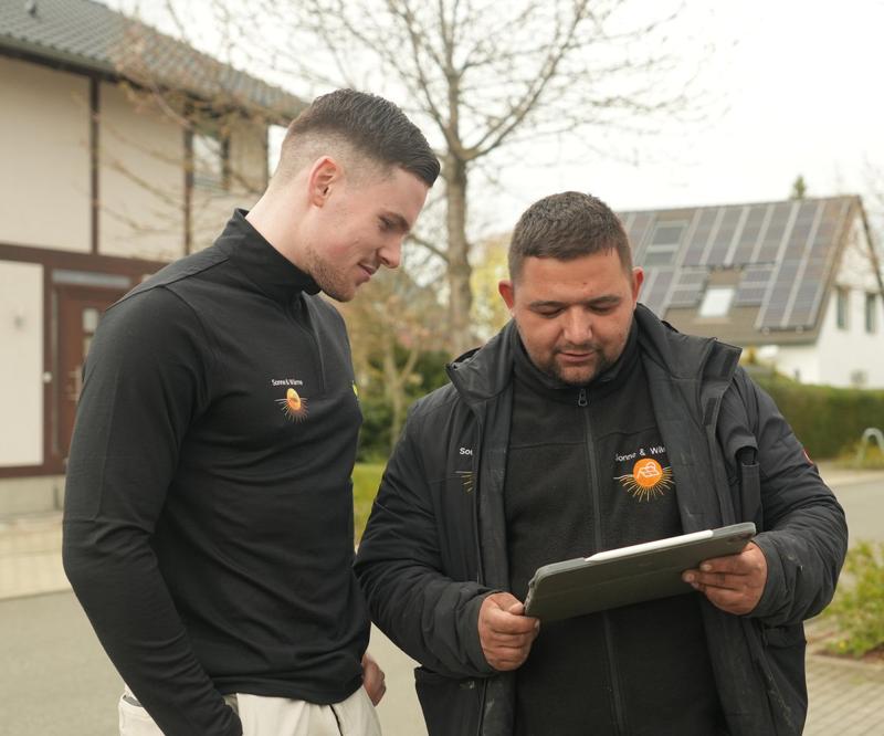 Zwei Mitarbeiter erfassen die Anlagendaten auf dem Tablet