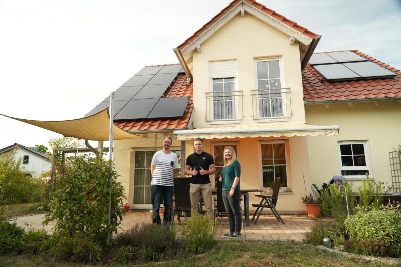 Familie und Team von Sonne & Wärme vor dem fertigen Haus mit Solaranlage